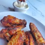 Roasted Party Wings Being Dipped In Homemade Buttermilk Ranch Dressing