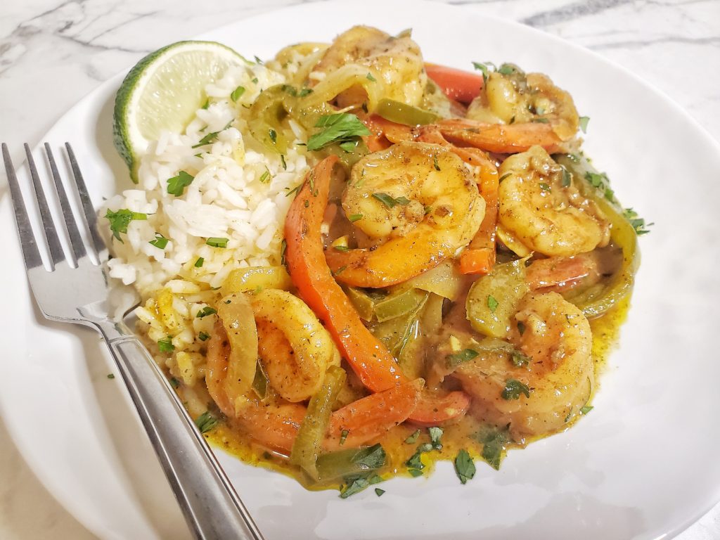 plate of coconut curry shrimp with a side of white rice
