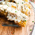 Grilled corn on a platter with garlic parmesan sauce