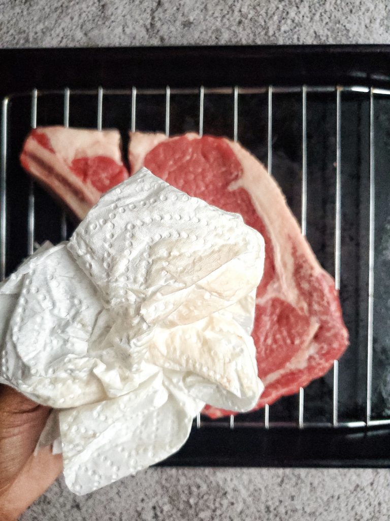 Ribeye steak being pat dry