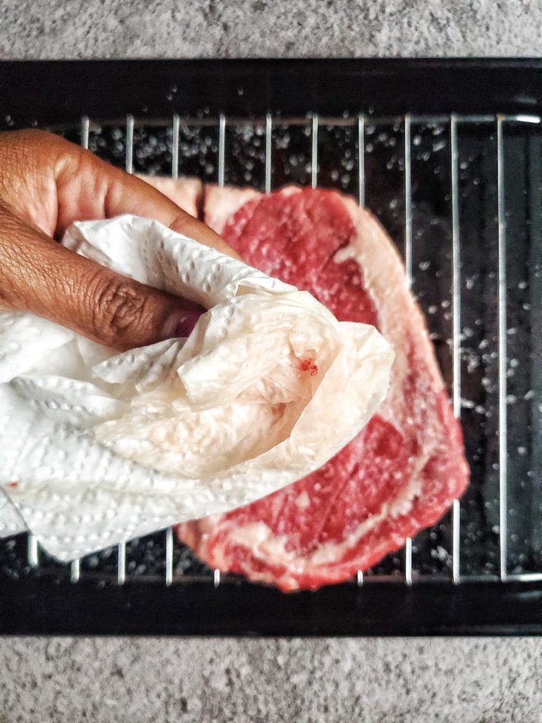 Ribeye steak being pat dry