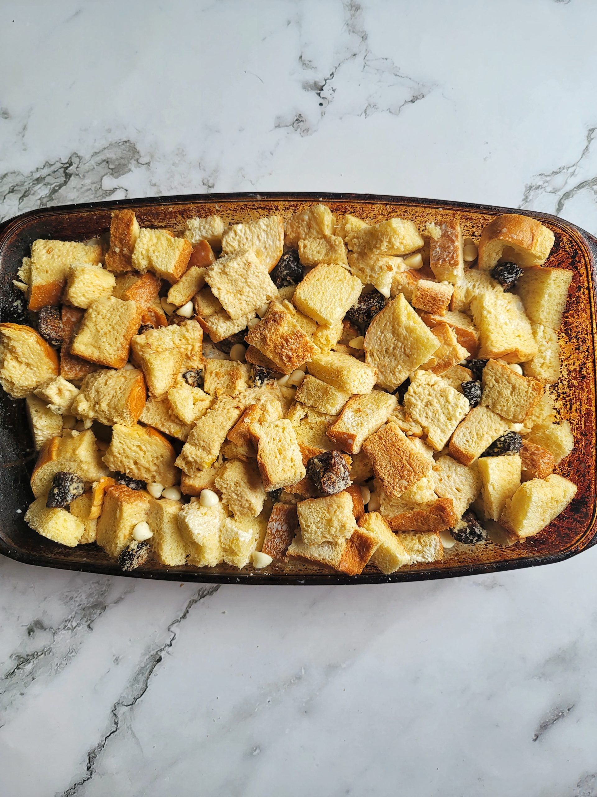 Cubed bread in a baking dish for bread pudding