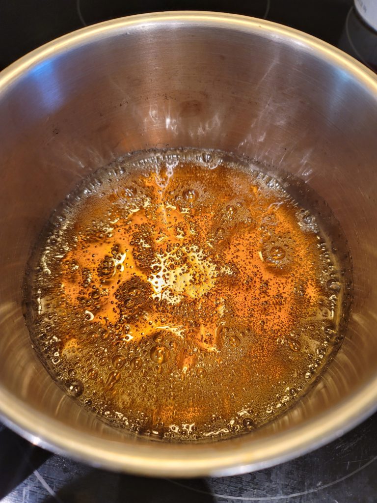 Sugar and water caramelizing in a small sauce pot