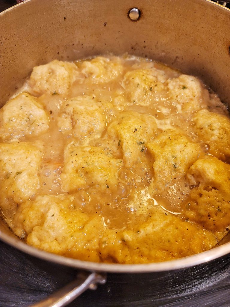 Partially cooked dumplings in broth for chicken and dumplings