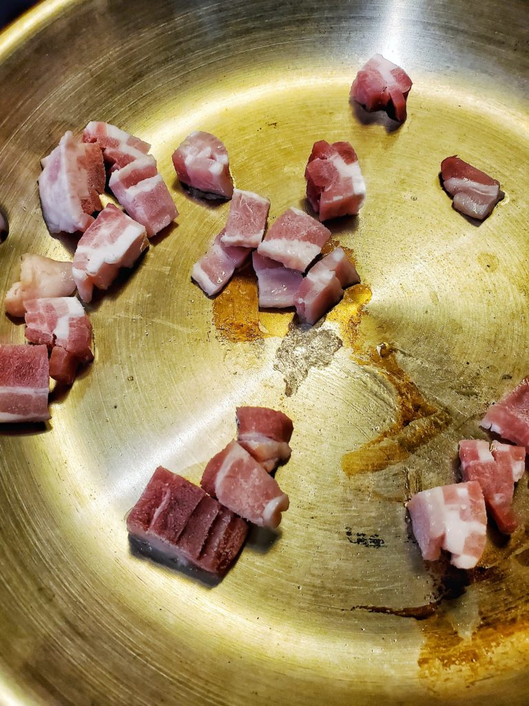 Raw diced bacon in a saute pan